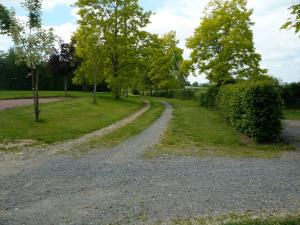 a gravel road in a park with trees and grass at Maison de campagne avec cuisine équipée et wifi, proche nature et activités aquatiques - FR-1-410-198 in Épineu-le-Chevreuil