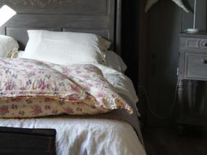 un letto bianco con cuscino e testiera in legno di Gîte Louplande, 4 pièces, 7 personnes - FR-1-410-203 a Louplande