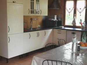 una cocina con armarios blancos y una mesa con mesa en Gîte Thoiré-sur-Dinan, 4 pièces, 6 personnes - FR-1-410-195, en Thoiré-sur-Dinan