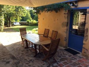 a wooden table and chairs on a patio at Gîte familial restauré en pleine nature avec terrasse, proche forêt, idéal pour groupes et PMR - FR-1-410-255 in Chemiré-en-Charnie