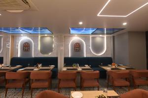a restaurant with tables and chairs and blue ceilings at KP Hotels in Begusarai