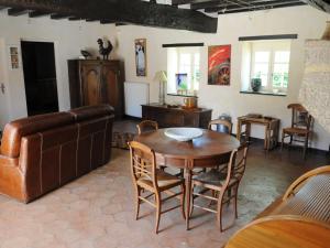 un soggiorno con un tavolo e un divano di Petite maison de campagne avec piscine chauffée, tennis et nombreuses activités pour tous! - FR-1-410-270 a Maresché