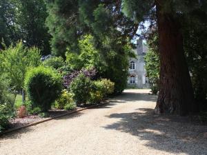a driveway in front of a house with trees and flowers at Charmant gîte près du Mans : calme, confort, commerces à proximité, idéal pour 2 pers. - FR-1-410-273 in Cérans-Foulletourte +13 photos