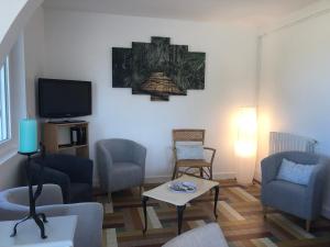ein Wohnzimmer mit Stühlen und einem Flachbild-TV in der Unterkunft Gîte Loir en Vallée, 5 pièces, 8 personnes - FR-1-410-274 in Ruillé-sur-Loir