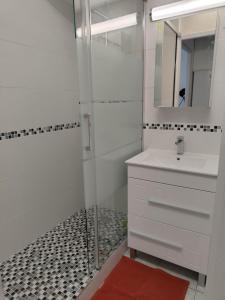 a bathroom with a shower and a sink and a mirror at Appartement La Corniche Vue océan in Mimizan-Plage