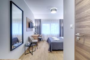 Habitación con cama, mesa y espejo. en Lawendowy Dwór, en Pszczółki