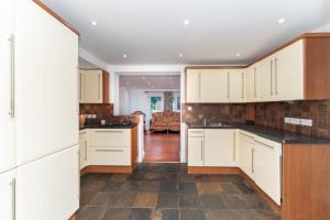 a kitchen with white cabinets and black counter tops at Luxury home in Gerrards Cross in Chalfont Saint Peter