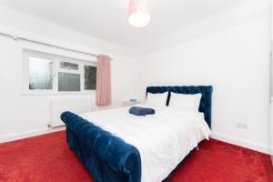 a bedroom with a large bed with a red carpet at Luxury home in Gerrards Cross in Chalfont Saint Peter