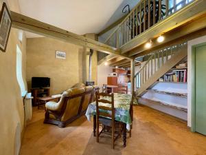 a living room with a staircase and a chair at Charmant Gîte à Lavaudieu avec Terrasse, Proche Sites Touristiques et Commerces - FR-1-582-219 in Lavaudieu