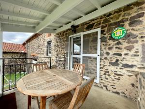 a wooden table and chairs on a porch with a stone wall at Charmant Gîte à Lavaudieu avec Terrasse, Proche Sites Touristiques et Commerces - FR-1-582-219 in Lavaudieu +14 photos