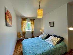 a bedroom with a blue bed and a window at Ferme restaurée avec jardin clos et terrasse, proche Puy en Velay - FR-1-582-271 in Le Monastier sur Gazeille