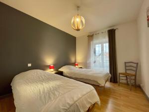 a bedroom with two beds and a table with a chair at Ferme du XIXe siècle avec cour fermée et terrasse, proche des gorges de la Loire et du Puy-en-Velay - FR-1-582-187 in Saint-Vincent
