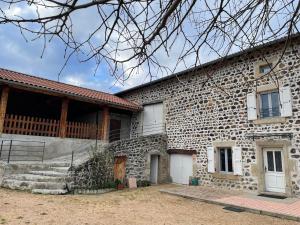 a stone house with a stone wall at Ferme du XIXe siècle avec cour fermée et terrasse, proche des gorges de la Loire et du Puy-en-Velay - FR-1-582-187 in Saint-Vincent