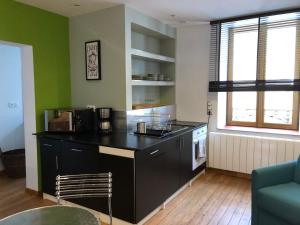 eine Küche mit einer schwarzen Arbeitsplatte in einem Raum in der Unterkunft Appartement 40m² lumineux avec cuisine équipée, Wi-Fi gratuit, proche mairie et église à Fay - FR-1-410-301 in Fay