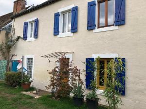 ein Haus mit blauen Fensterläden und Pflanzen im Hof in der Unterkunft Gîte Fay, 2 pièces, 4 personnes - FR-1-410-301 in Fay