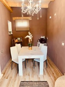 a dining room with a white table and chairs at VILLA di L ABBIU FARMHOUSE , ROOMS DESIGN & RELAX in Sorso