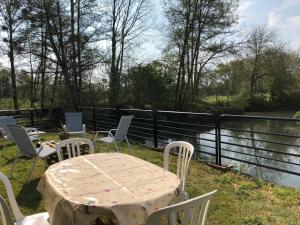 a table and chairs on a balcony with a fence at Moulin Authentique avec Pêche, Animaux Acceptés et Confort Moderne près du Mans - FR-1-410-323 in Mézières-sur-Ponthouin