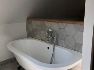 a bath tub with a faucet in a bathroom at Charmant Gîte Campagnard près du Mans - Calme, Confort et Commodités à Proximité - FR-1-410-327 in Cérans-Foulletourte