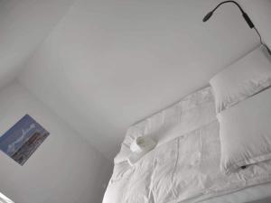 a white bed with a lamp on top of it at Ilulissat Hostel in Ilulissat
