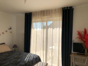 um quarto com uma cama e uma janela com cortinas em Gîte Saint-Georges-du-Bois, 2 pièces, 2 personnes - FR-1-410-336 em Rouillon