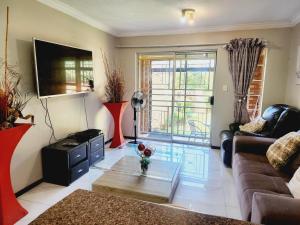 a living room with a couch and a table at Mooikloof Mews with Solar Backup in Pretoria