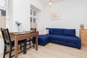 a living room with a blue couch and a table at Studio Apartment near River and Park by Rent like home in Gdańsk