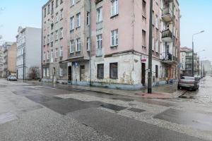 an old building on a city street with cars parked at Studio Apartment near River and Park by Rent like home in Gdańsk