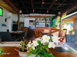 a dining room with a table with white flowers on it at Rene's Resort in Calape