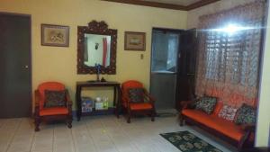 a living room with two chairs and a mirror at Santarem uri del flu in Iloilo City