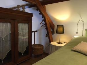 een slaapkamer met een bed en een tafel met een lamp bij Gîte Drevant, 2 pièces, 3 personnes - FR-1-586-25 