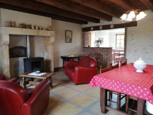 a living room with red furniture and a fireplace at Gîte rénové au calme avec grand terrain, idéal télétravail, proche forêt et karting - FR-1-586-27 in La Celette