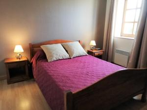 a bedroom with a bed with a purple comforter and two lamps at Gîte La Celette, 4 pièces, 6 personnes - FR-1-586-27 