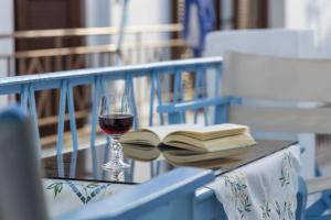 a glass of wine and a book on a table at Rustic House in Plaka in Plaka Milou +21 photos
