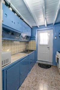 a kitchen with blue cabinets and a white door at Rustic House in Plaka in Plaka Milou