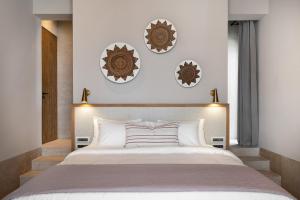 ein Schlafzimmer mit einem großen Bett und drei Tellern an der Wand in der Unterkunft Eliámos Villas Hotel & Spa - Relais & Châteaux in Sparta + 51 Fotos