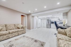 a living room with a couch and a table and a kitchen at Hidden Gem: Spacious Basement in Milton