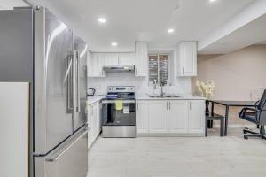 a kitchen with a refrigerator and a table in it at Hidden Gem: Spacious Basement in Milton