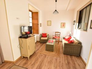 salon z 3 krzesłami i telewizorem w obiekcie Gîte restauré 6 pers. au bord de la rivière, proche centre, parking et wifi - FR-1-410-380 w mieście Sablé-sur-Sarthe