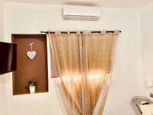 uma cortina de chuveiro na casa de banho com um coração na parede em VILLA di L ABBIU FARMHOUSE , ROOMS DESIGN & RELAX em Sorso