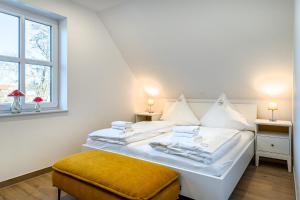 - une chambre avec un lit doté de draps blancs et une fenêtre dans l'établissement Paula, neu, Balkon und Mühlenblick!, à Greetsiel