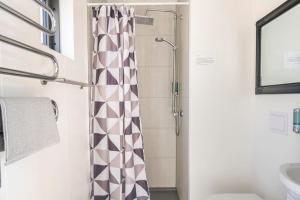 a bathroom with a shower curtain and a sink at Laxárdalur Cabin in Einarsstaðir