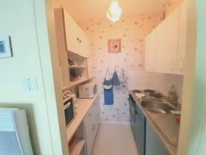 uma pequena cozinha com um lavatório e um balcão em Appartement Saint-Hilaire-de-Riez, 2 pièces, 5 personnes - FR-1-324A-2 em Saint-Hilaire-de-Riez