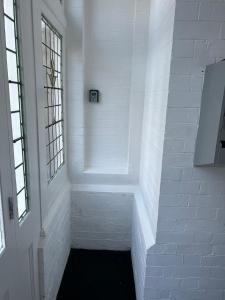 um corredor com paredes de tijolos brancos e uma janela em 1 Bedroom Flat with Parking em Leicester