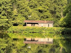 Chalet nature avec étang, terrasse et pêche No Kill - 2 chambres - FR-1-410-383 في Dehault: يوجد منزل بجوار مسطح مائي