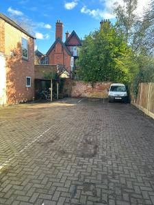 a car parked in a parking lot next to a brick wall at 1 Bedroom Flat with Parking in Leicester