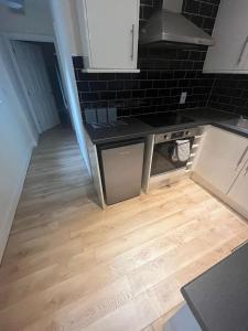 a kitchen with a stove and a wooden floor at 1 Bedroom Flat with Parking in Leicester