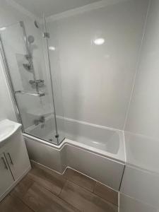 uma casa de banho branca com um chuveiro e um lavatório. em 1 Bedroom Flat with Parking em Leicester