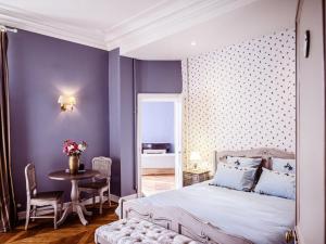sypialnia z fioletowymi ścianami, łóżkiem i stołem w obiekcie Grand Château Renaissance avec Parc, Piscine et Activités, Rénové en 2023 - FR-1-410-389 w mieście Vallon-sur-Gée