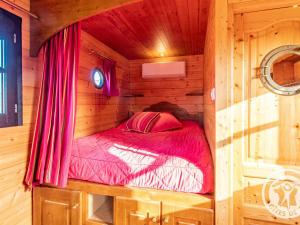 a bedroom with a bed in a wooden cabin at Roulotte climatisée avec piscine et jardin - FR-1-622-54 in Vihiers