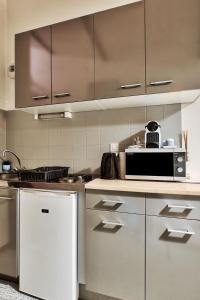 a kitchen with stainless steel appliances and a microwave at Le Chaleureux Bressan in Bourg-en-Bresse